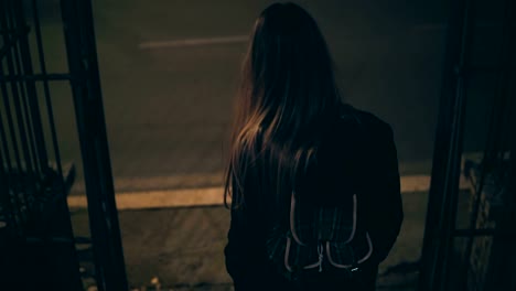 Mujer-morena-joven-viene-abajo-frente-al-Coliseo-en-Roma,-Italia.-Chica-caminando-en-la-ciudad-tarde-en-la-noche