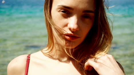 blonde-Frau-mit-Sommersprossen-im-Gesicht-posiert-am-Strand