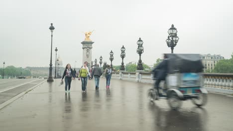 Gente-caminando-sobre-el-puente-de-Alexandre-III-en-un-día-rainny