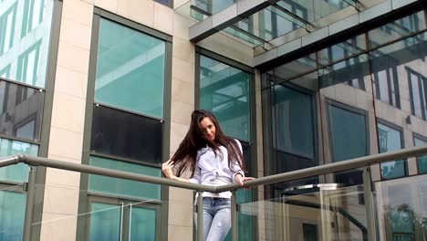 Girl-with-long-hair-standing-near-modern-building.