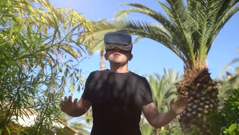 Video-de-hombre-explorando-la-realidad-virtual-en-el-jardín-tropical-de-4k