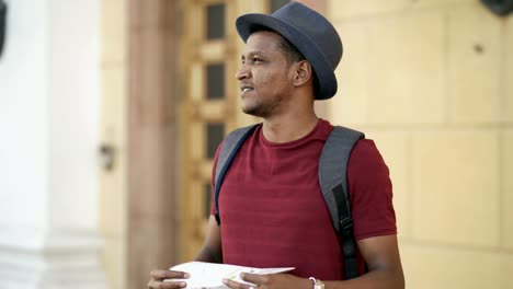African-american-tourist-man-looking-into-paper-city-map-exploring-sightseeings-during-travelling-in-Europe