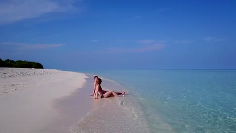 v03871-Aerial-flying-drone-view-of-Maldives-white-sandy-beach-2-people-young-couple-man-woman-romantic-love-on-sunny-tropical-paradise-island-with-aqua-blue-sky-sea-water-ocean-4k