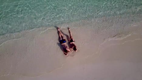 v04032-vuelo-drone-vista-aérea-de-Maldivas-playa-2-personas-pareja-hombre-mujer-amor-romántico-en-la-isla-de-paraíso-tropical-soleado-con-cielo-azul-aqua-agua-mar-4k