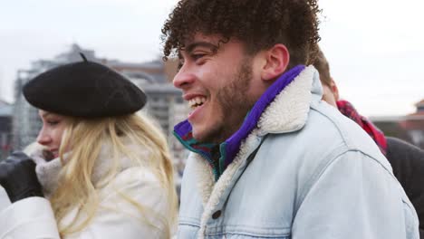 Gruppe-junger-Freunde-zu-Fuß-über-Millennium-Bridge-In-London