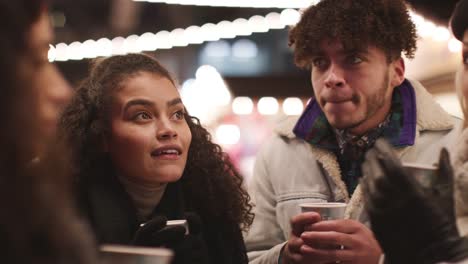 Grupo-de-amigos-tomando-vino-caliente-en-el-mercado-de-Navidad