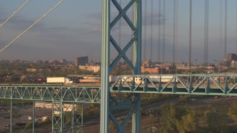 AERIAL:-Semi-trucks-crossing-bridge-shipping-goods-into-Ontario-on-sunny-morning