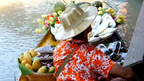 Vendedor-de-frutas-exóticas-en-un-barco-y-un-sombrero-de-paja-las-velas-en-el-río-en-Tailandia,-en-un-mercado-flotante,-Pattaya