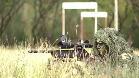 Francotirador-soldado-tendido-en-el-suelo-y-camuflaje-en-hierba.-Soldado-con-arma-pistola-y-waring-armadura-uniforme.-El-ejército-es-responsable-de-mantener-el-territorio.