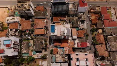 Drone-flying-over-buildings-of-Colombo,-Sri-Lanka-towards-seashore.-Aerial-top-view-of-Asian-resort-town-and-ocean