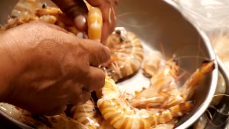 Hands-taking-off-shrimp-shells-before-cook.