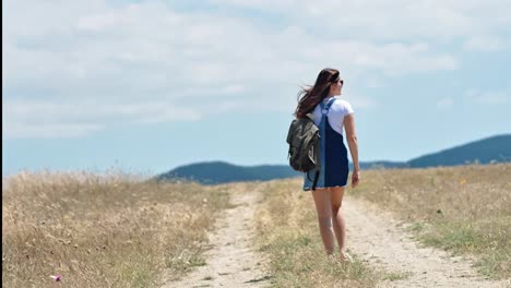 Activa-mujer-caminante-disfrutando-el-paisaje-de-la-montaña-rodeado-de-hierba-seca-vista-trasera