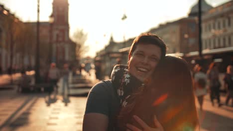 A-guy-meets-a-girl-walking-down-the-street-and-gives-her-a-hug,-close-up