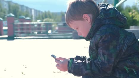 Boy-types-and-sends-a-message-on-a-mobile-phone.