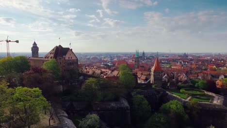 Luftbild-Stadt-mit-einer-Burg-im-Vordergrund-während-des-Fluges-auf-einem-Turm