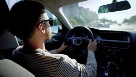 Vista-desde-el-asiento-trasero-de-un-hombre-conduciendo-un-coche-de-lujo-con-salón-de-cuero