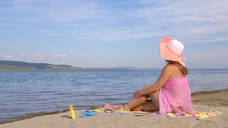 Beautiful-woman-is-resting-on-the-beach-and-looking-at-the-sea.