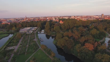 Aerial-view-flying-over-Malmo-cityscape-at-sunset.-Drone-shot-of-"Malmohus"-in-Sweden,-Turning-Torso-building-in-the-background