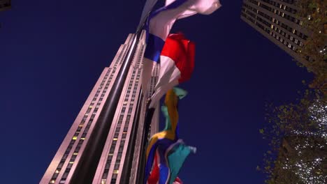 Video-de-algunas-banderas-movidas-por-el-viento-en-el-primero-plano-y-los-Rockefeller-en-el-fondo-en-Manhattan,-Nueva-York.