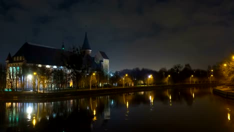 Beleuchtung-in-einem-historischen-Gebäude.-Historisches-Wahrzeichen.-Zeitraffer.-Kathedrale-von-Kant-in-Kaliningrad.-Alte-mittelalterliche-nachts-gegen-den-Himmel.-Zeitraffer.-Stadtpark-mit-einem-Fluss,-einem-Teich.