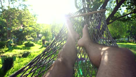 A-man-swinging-in-a-hammock-pov