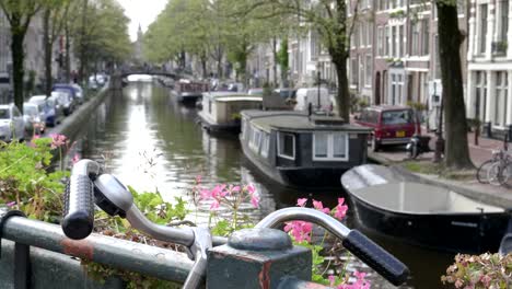 Fahrrad-Lenker-und-einer-geringen-Tiefe-von-Feld-Schuss-von-einer-Gracht-in-amsterdam