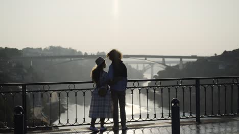 Paar-in-der-Silhouette,-umarmen-und-küssen-auf-Brücke