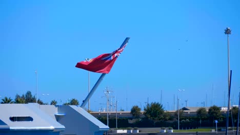 Eine-große-englische-Flagge,-die-auf-dem-Heck-eines-großen-Schiffes-montiert-ist,-das-im-Wind-flattert