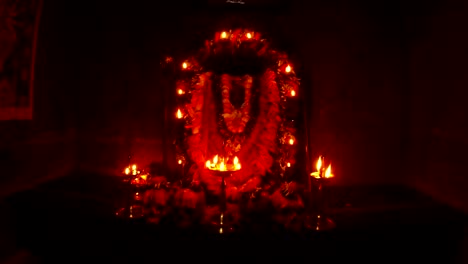 Altar-of-godess-Kali-Ma-human-sculls-with-flowers-statue-decorated-with-garland-and-burning-candles