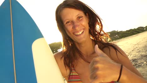Smiling-young-woman-showing-surf-sign-with-her-hand