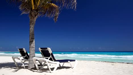 Tropical-beach-with-sun-umbrellas-and-beds