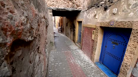 Un-niño-en-los-doce-años-que-pasan-con-como-bicicletas-en-una-estrecha-calle-peatonal-en-Essouira