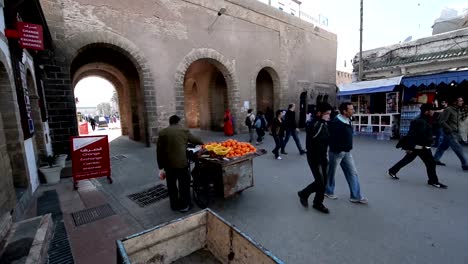 Menschen-gehen-in-und-außerhalb-der-Stadtmauern-auf-eine-große-Fußgängerzone-im-Essouira