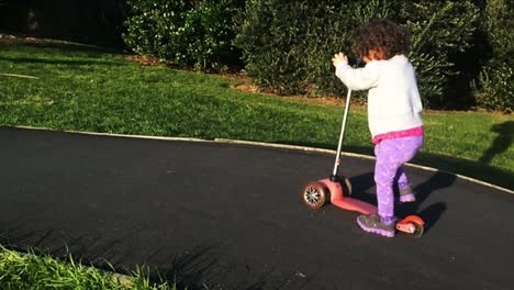 Slow-motion-child-ride-a-scooter-in-the-park