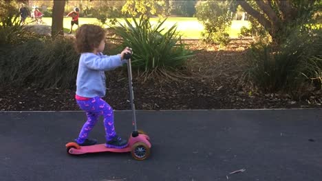 Slow-Motion-Kind-reiten-einen-Roller-im-park