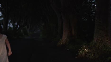 4k-Horror-Shot-of-Child-Running-Scared-in-Dark-Hedges,-N.-Ireland