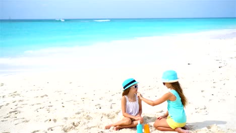 Kids-applying-sun-cream-to-each-other-on-the-beach.-The-concept-of-protection-from-ultraviolet-radiation