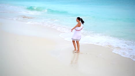 Junge-schöne-Frau-am-tropischen-Strand.-Über-Ansicht-der-glücklichen-Mädchen-in-schönen-Kleid-am-weißen-Strand