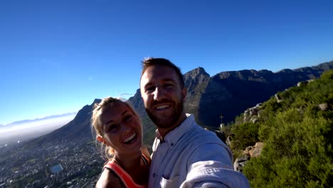 Joven-pareja-teniendo-selfie-con-paisaje-urbano-de-ciudad-del-cabo-al-amanecer