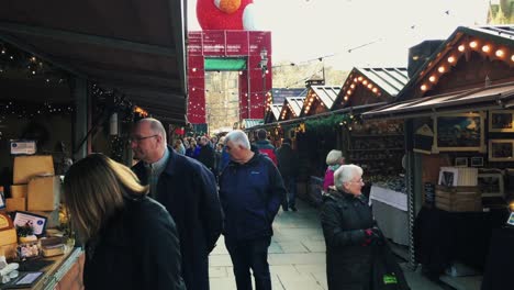 MANCHESTER,UK---DECEMBER-16,-2016.-Shot-of-shoppers-at-the-Christmas-market-in-front-of-the-Manchester-Town-Hall-on-Albert-Square.-December-16,-2016