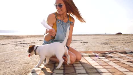 stilvolle-junge-Hipster-spielenden-Hund-Welpen-jack-Russell-am-Strand,-Slow-motion