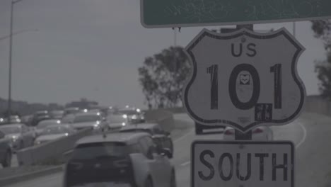 Cars-in-traffic-passing-by-US-101-South-sign-in-San-Francisco---uncolored-log-footage