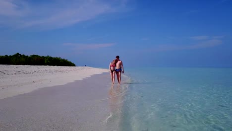 v03972-fliegenden-Drohne-Luftaufnahme-der-Malediven-weißen-Sandstrand-2-Personen-junges-Paar-Mann-Frau-romantische-Liebe-auf-sonnigen-tropischen-Inselparadies-mit-Aqua-blau-Himmel-Meer-Wasser-Ozean-4k