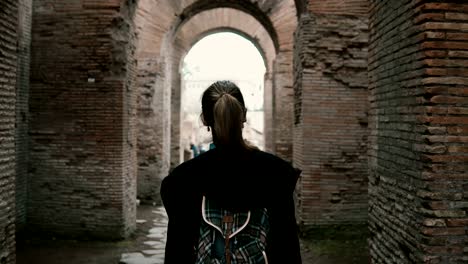 Girl-tourist-is-walking-in-historical-centre-of-Rome,-Italy.-Woman-passing-the-chain-of-ancient-arcs-made-of-red-brick