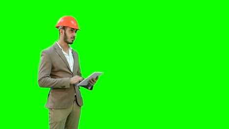 Ingeniero-en-el-casco-de-seguridad-realizar-inspección-con-tablet-a-una-pantalla-verde-Chroma-Key