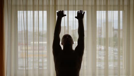 Silhouette-of-man-doing-Tai-Chi-at-home-in-front-of-window.-Morning-asian-practice.-Locked-indoors.