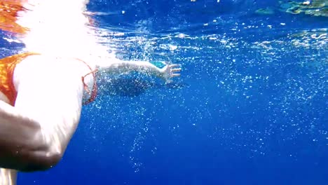 Inmersión-de-mujer-bajo-el-agua-en-la-máscara-de-buceo-snorkel