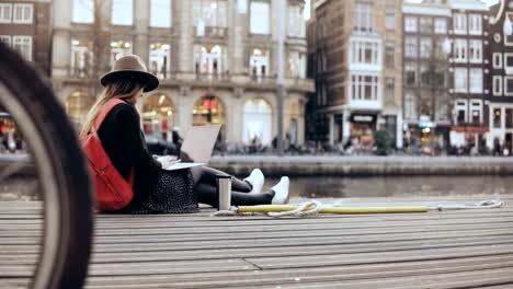 4K-Young-creative-girl-sits-with-laptop-outside.-Fashion-art-blogger-works-outdoors.-Freedom.-Steadicam-lifestyle-shot