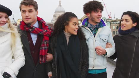 Gruppe-junger-Freunde-zu-Fuß-über-Millennium-Bridge-In-London