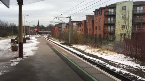 Swoops-del-pájaro-a-través-de-una-plataforma-de-tren-abandonada-en-un-día-de-invierno